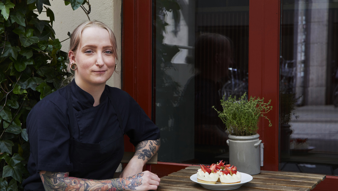 Konditorchef Line Wolter med de færdige jordbærkager. Siddepladsen udenfor er konditoriets eneste, for det er meget lille. “Vi har ingen siddepladser indenfor, og det er lidt ærgerligt. Derfor har vi netop lavet en aftale med bistroen inde ved siden af om, at man kan købe kagerne hos dem og sidde derinde,” siger hun.   