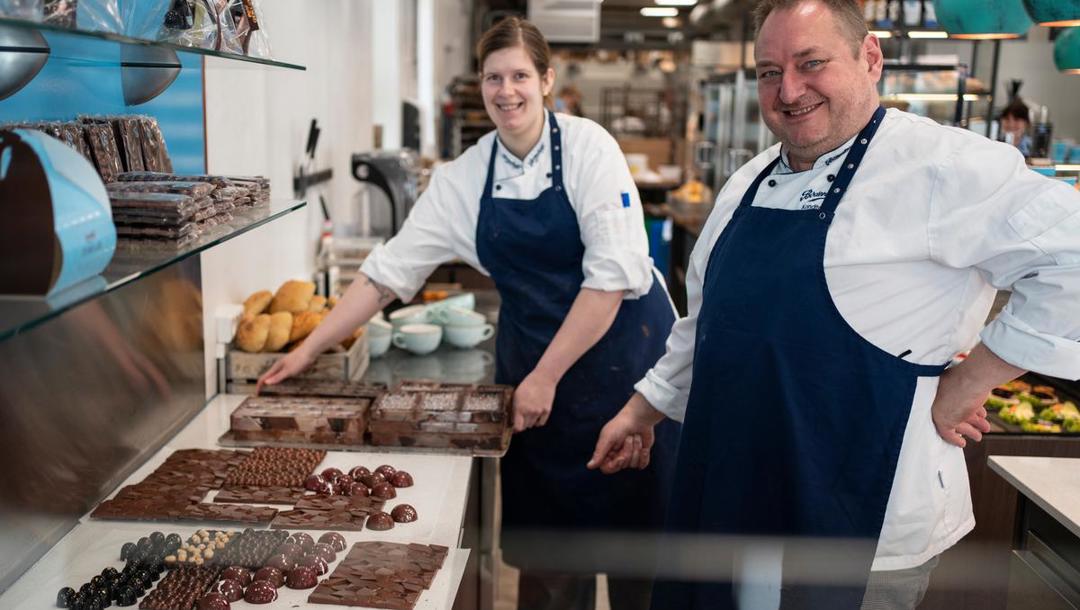 Det er chefkonditor Allan Andersen og bager og konditor Maria Seremet, der i øjeblikket står for chokoladeproduktionen. Her er de i gang med at lave fyldte chokolader med lakrids og kugler med karamelfyld. De sprayfarver selv deres forme med kakaosmør, og der går sjældent noget af produktionen til spilde, for der er styr på tempereringen. 