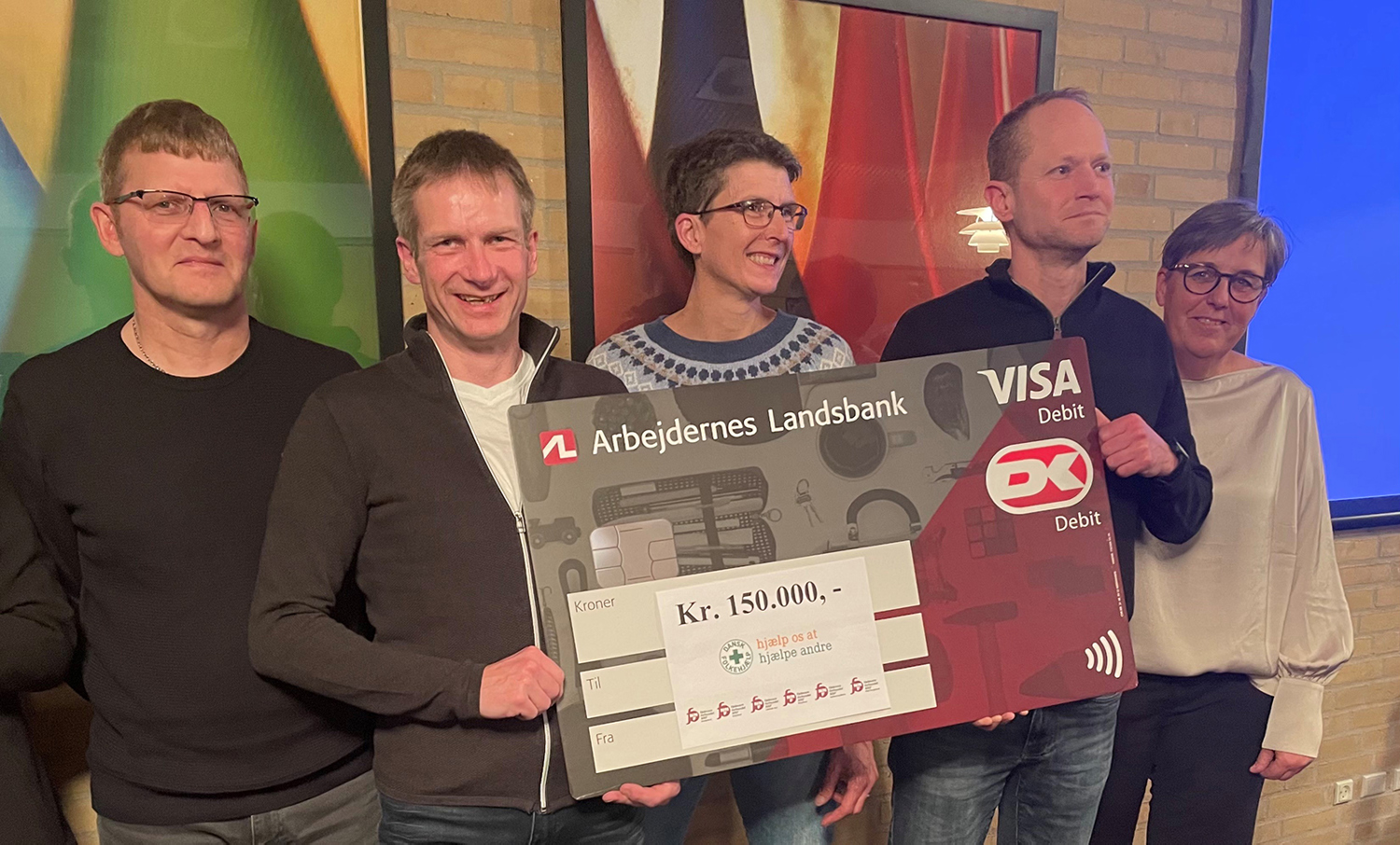 Medlemmer af afdelingsbestyrelserne med en check på 150.000 kr. til Dansk Folkehjælp.