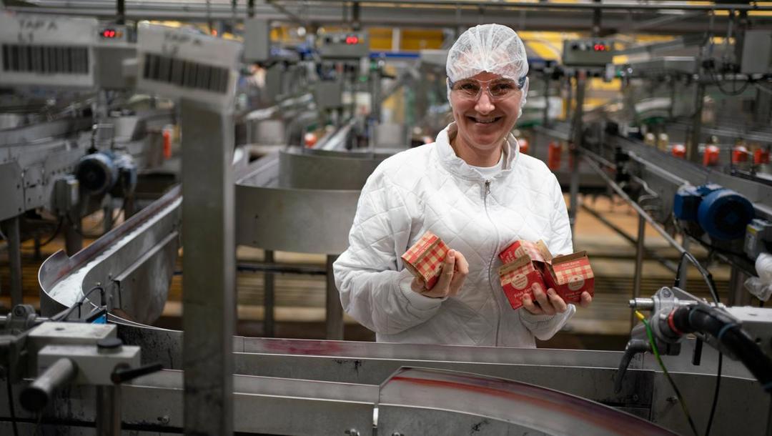 På tapperiet hældes fløden, som ikke bruges i produktionen, over på de velkendte kartoner. Anastasia Karpova er først for nylig startet op arbejdspladsen, så hun synes, det gælder om at have tungen lige i munden, når hun kontrollerer, at maskinen kører, som den skal. Hun sørger for at kartonerne er tætte, datoen passer og sidder som den skal, og at vægten passer med det, der står på emballagen.